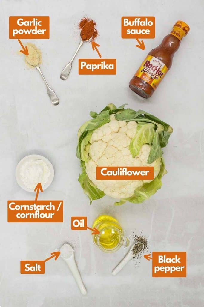 Ingredients needed, garlic powder, paprika, buffalo sauce, cauliflower, cornstarch, olive oil, black pepper, and salt.