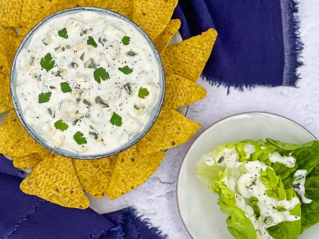 Homemade blue cheese dressing in a bowl, with tortillas, and a lettuce leaf with it on.