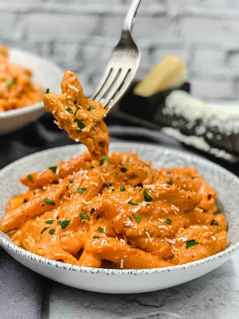 Homemade penne alla vodka in a bowl and on a fork.