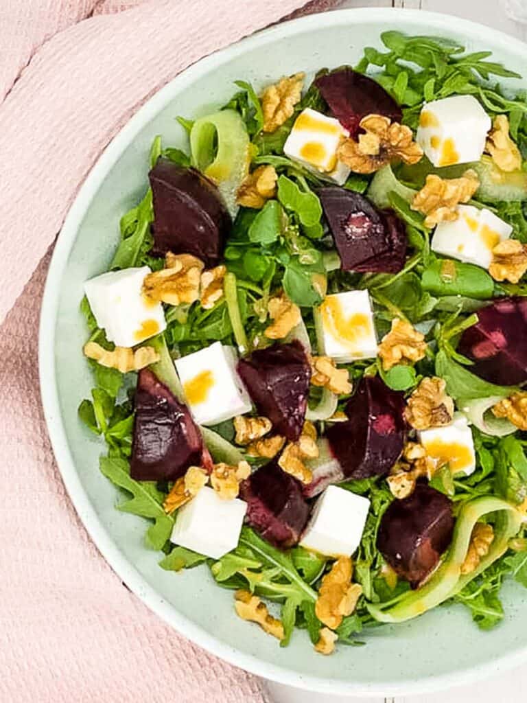 Roasted beet and feta salad in a bowl with a pink napkin.