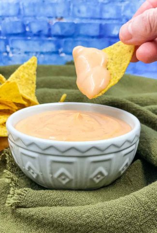 Homemade sriracha aioli with someone dipping a tortilla in it.