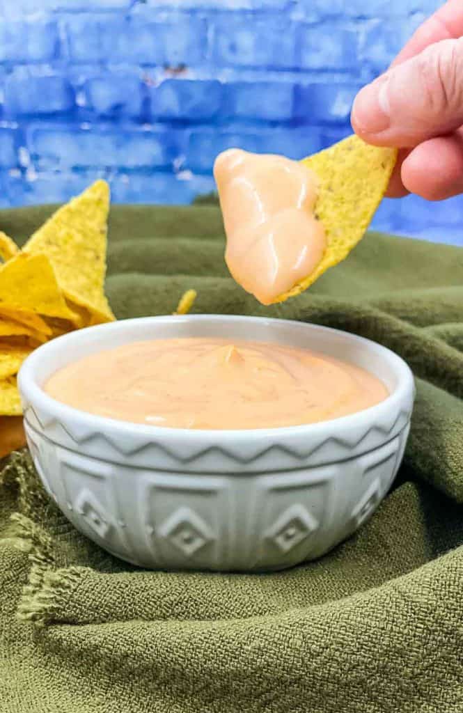 Homemade sriracha aioli with someone dipping a tortilla in it.