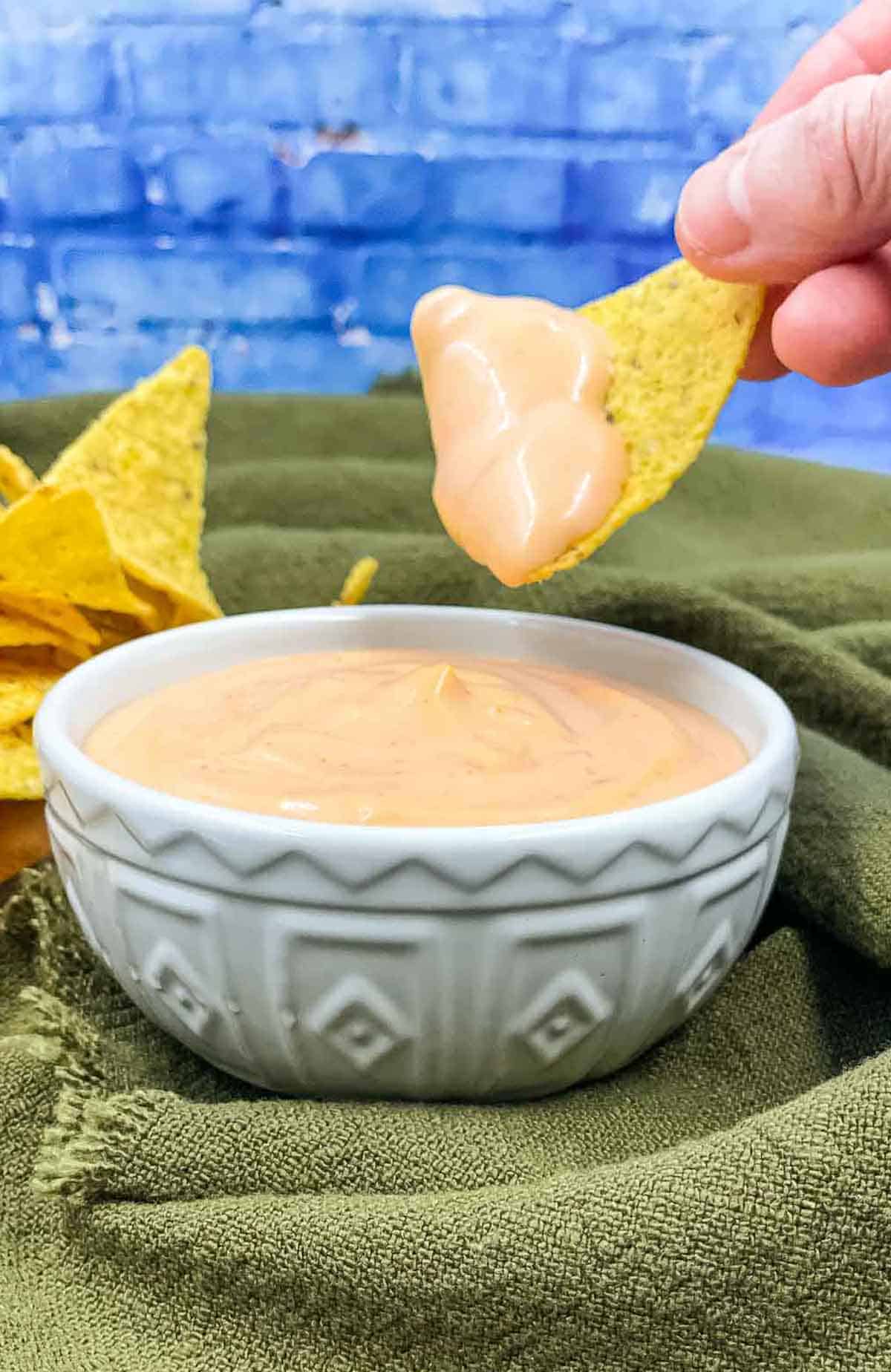 Homemade sriracha aioli with someone dipping a tortilla in it.