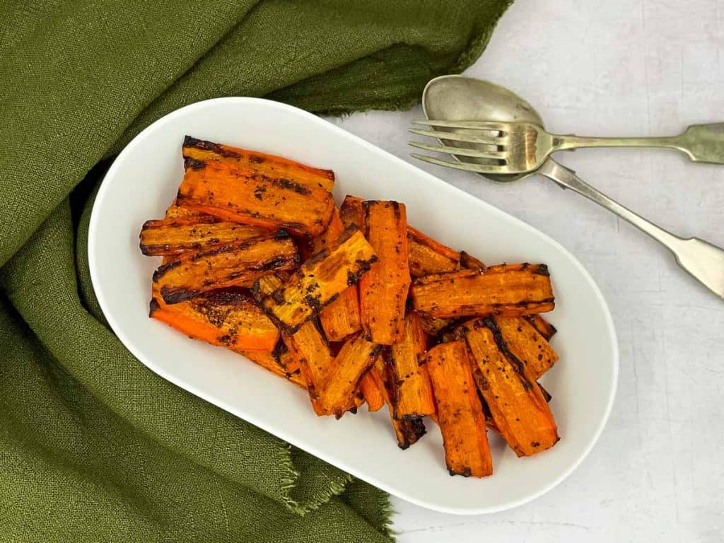 A serving dish with maple roasted air fryer carrots.