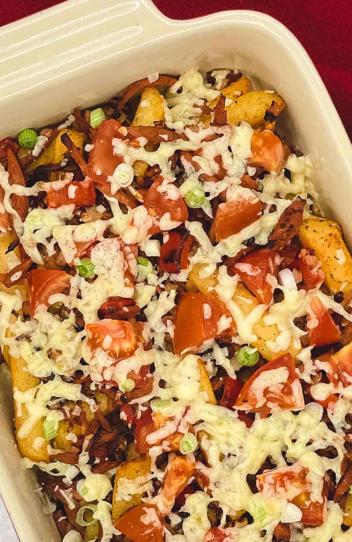 Loaded fries with cheese, tomatoes, green onion, and veggie bacon.
