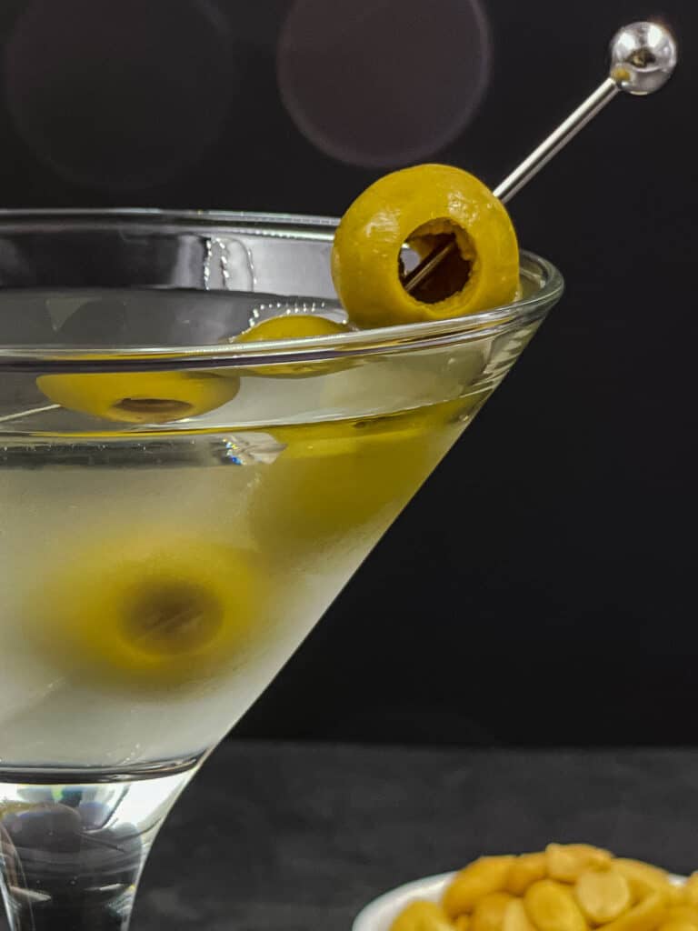 Half a dirty martini glass with olives