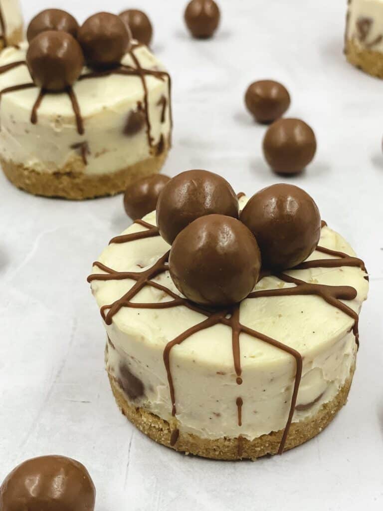 Mini Malteser cheesecakes, with Maltsers scattered around them.