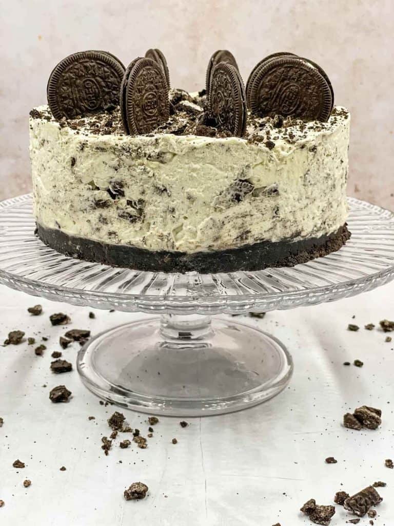 An Oreo cheesecake on a cake stand.