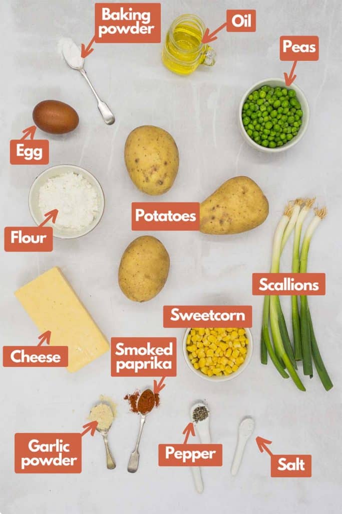 Ingredients needed, egg, baking powder, olive oil, peas, potatoes, scallions, flour, cheddar cheese, sweetcorn, garlic powder, smoked paprika, pepper, and salt.