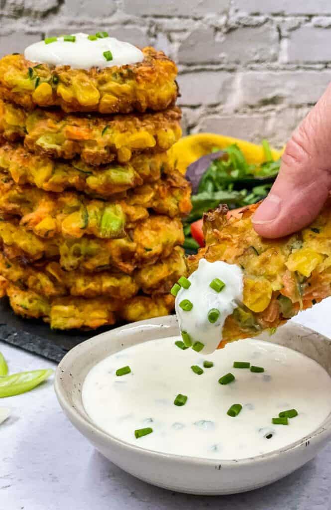 Vegetable fritters with sour cream and chive dip, and chopped chives.