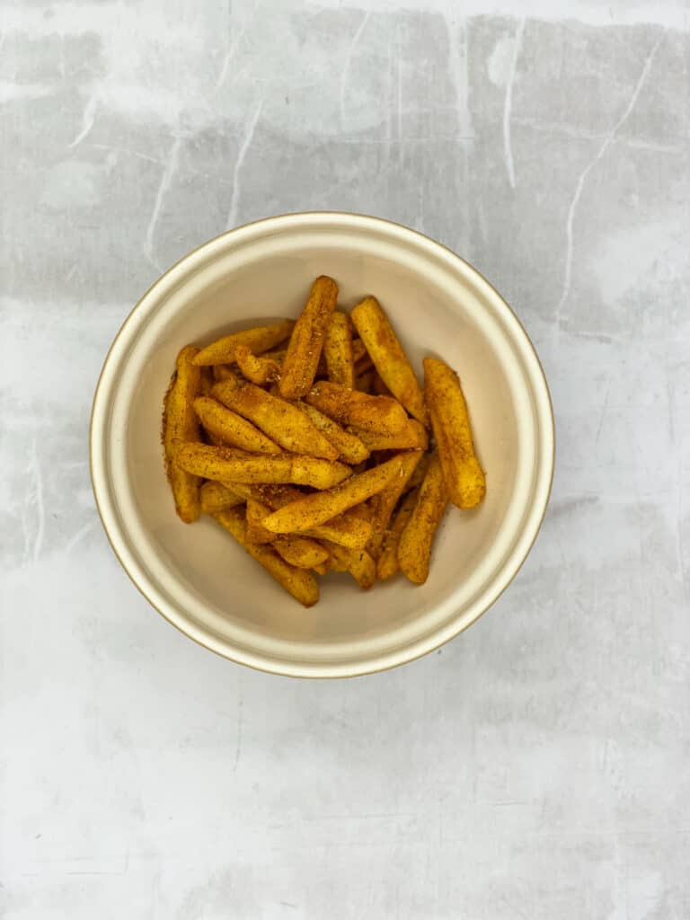 Toss the frozen oven chips in the masala blend.