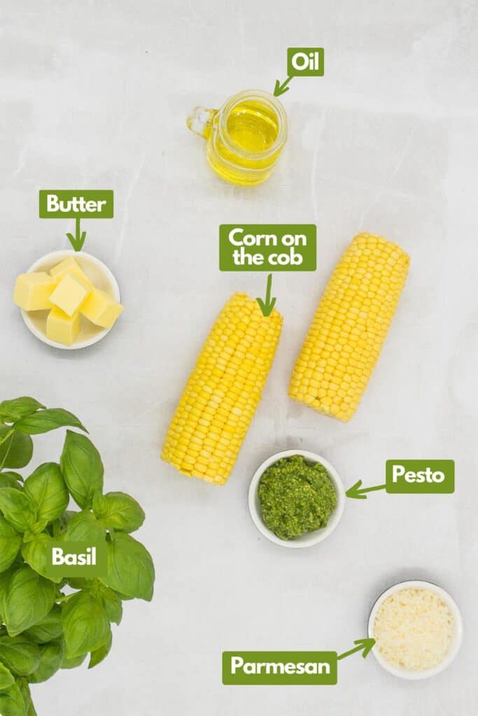 Ingredients needed, olive oil, corn on the cob, pesto, vegetarian Parmesan, fresh basil. and butter.