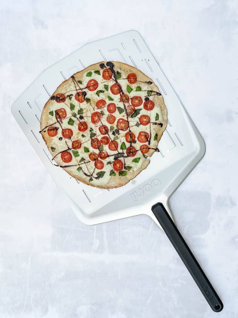 Fresh out of the oven pizza on a piza paddle.
