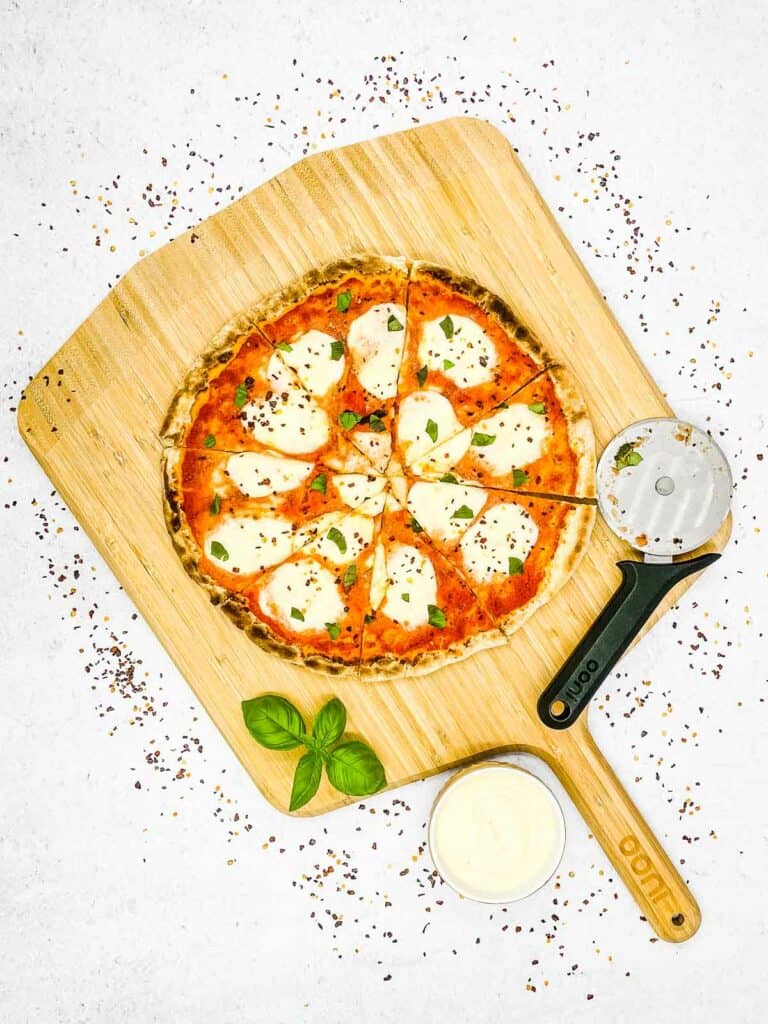 A delicious Margherita pizza on a wooden board.