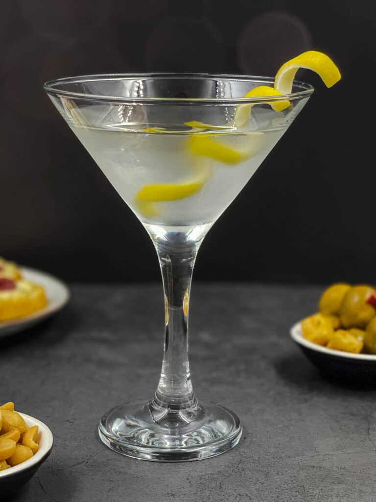 Vesper martini in a cocktail glass with a yellow lemon twist in the glass.