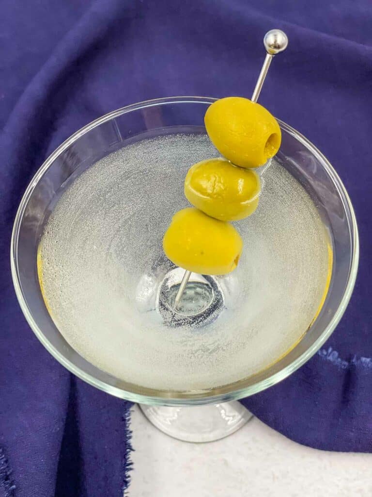 Vodka martini cocktail with 3 green olives.