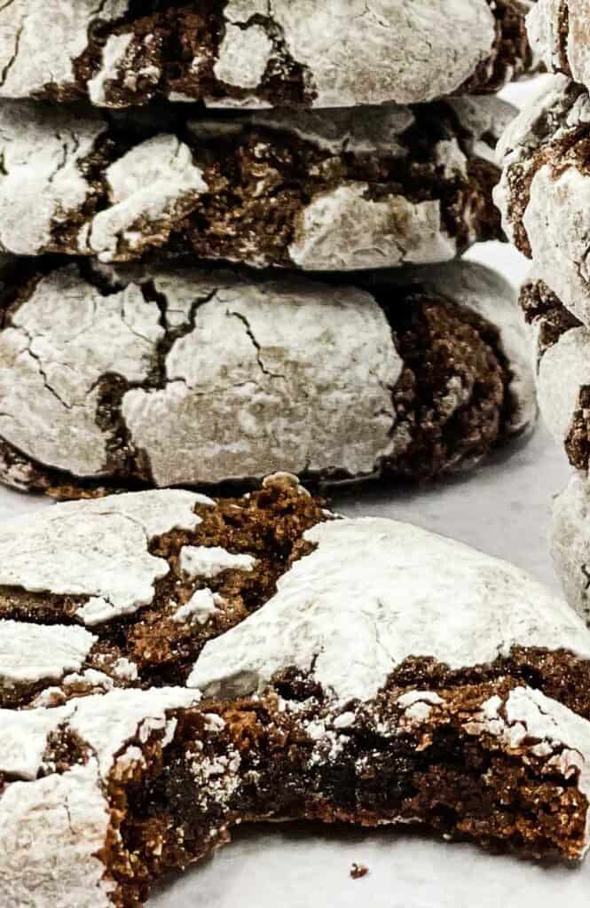 Air fryer chocolate crinkle cookies in a stack and one with a bite out of it.