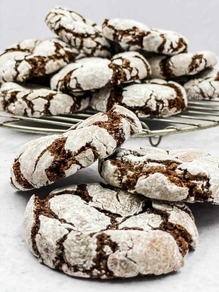 Air fryer chocolate crinkle cookies on a rack and in front of it.