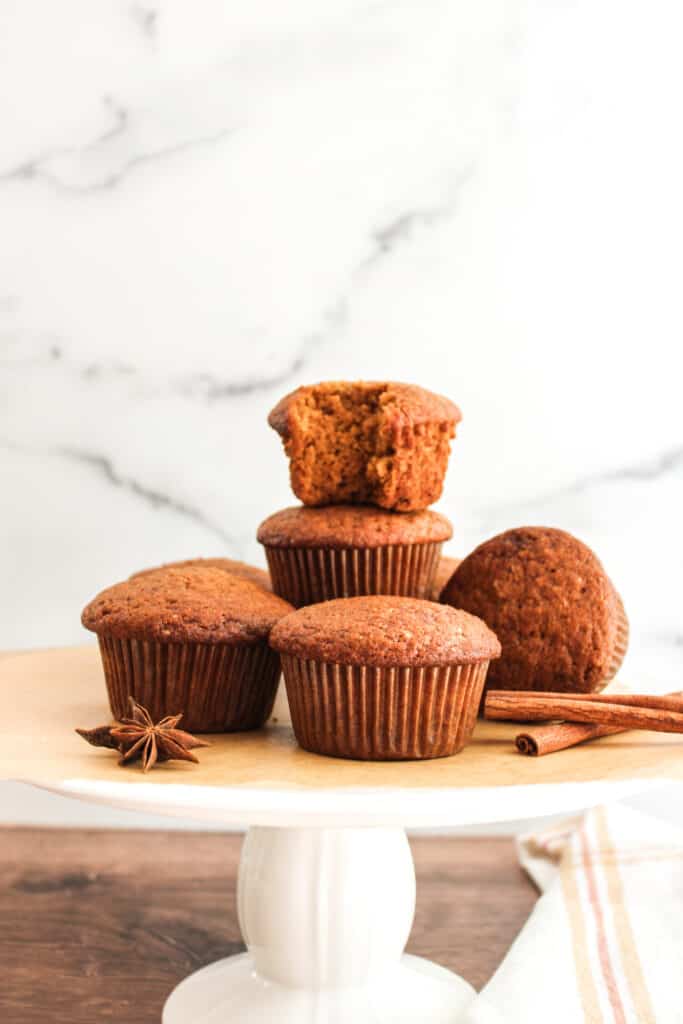Delicious pumpkin muffins on a cake stand with spices.