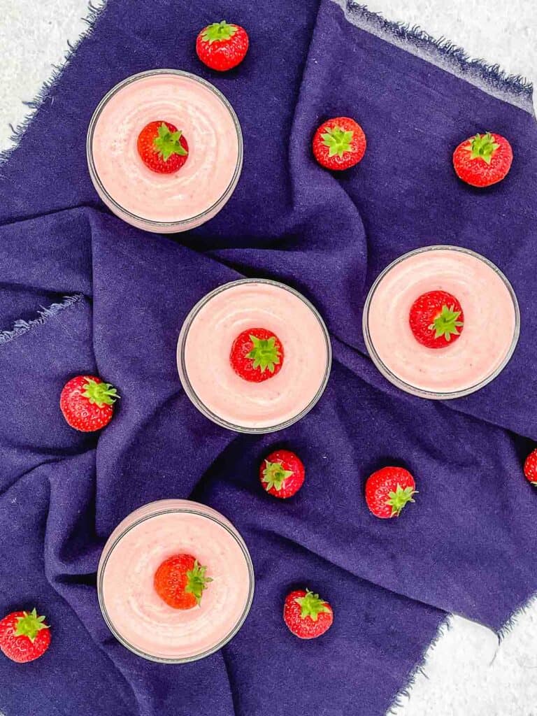 Strawberry mousse desserts, with strawberries surrounding them.