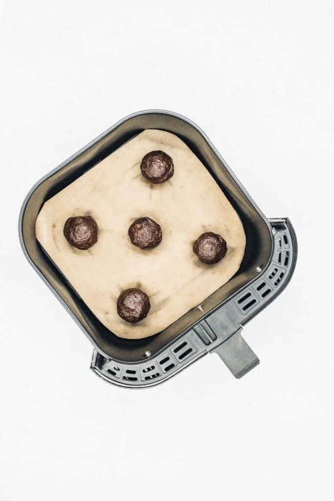 Place the cookie dough balls in the air fryer basket.
