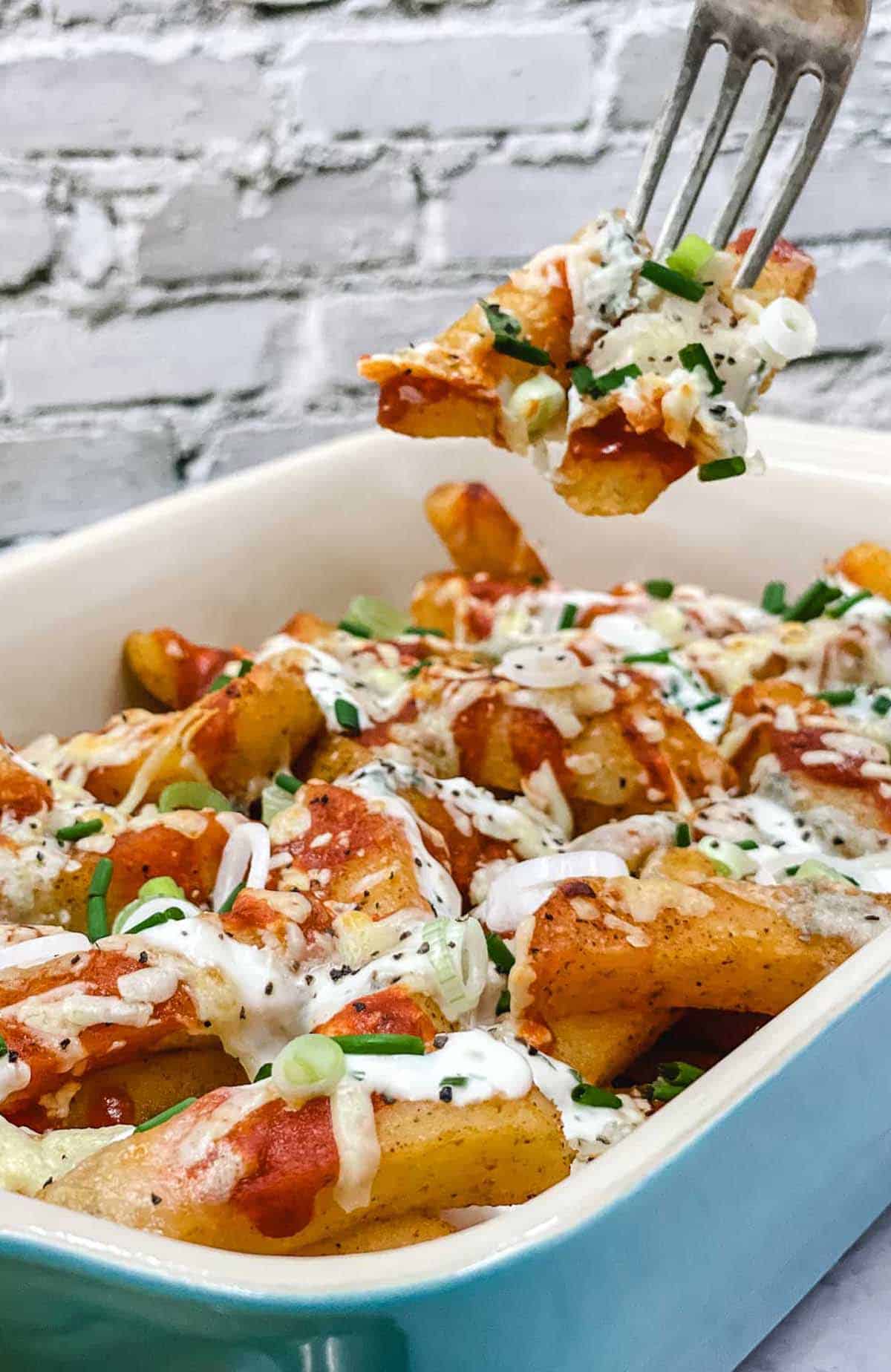 A forkful of vegetarian buffalo fries, and a dish full of them.