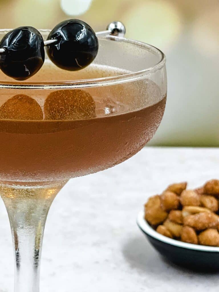 Manhattan drink with cherries and nuts.