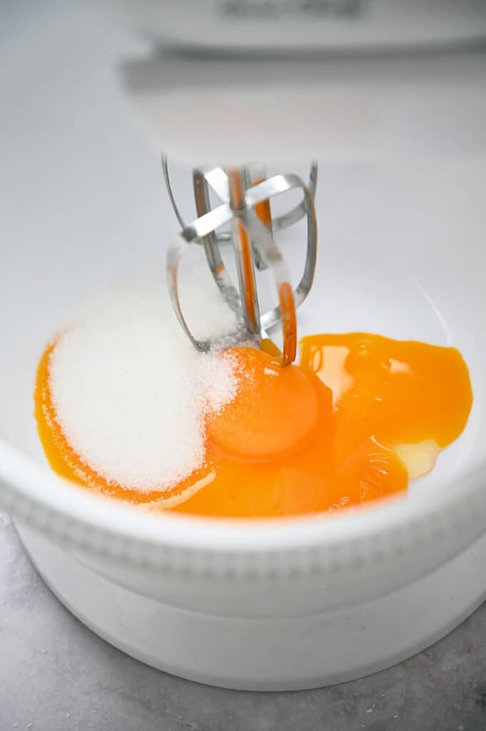 Whisk, whisking eggs and sugar.