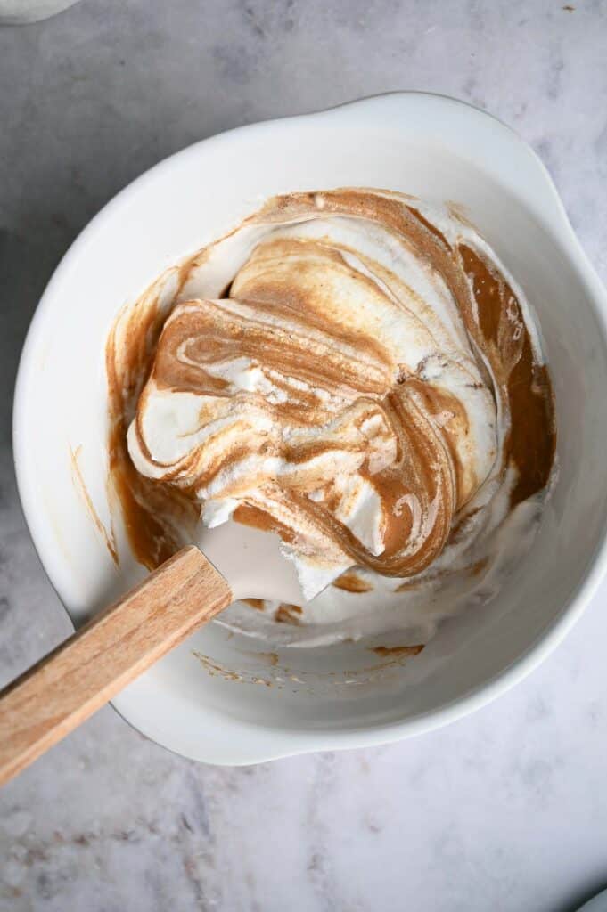 Folding egg whites and chocolate in a bowl..