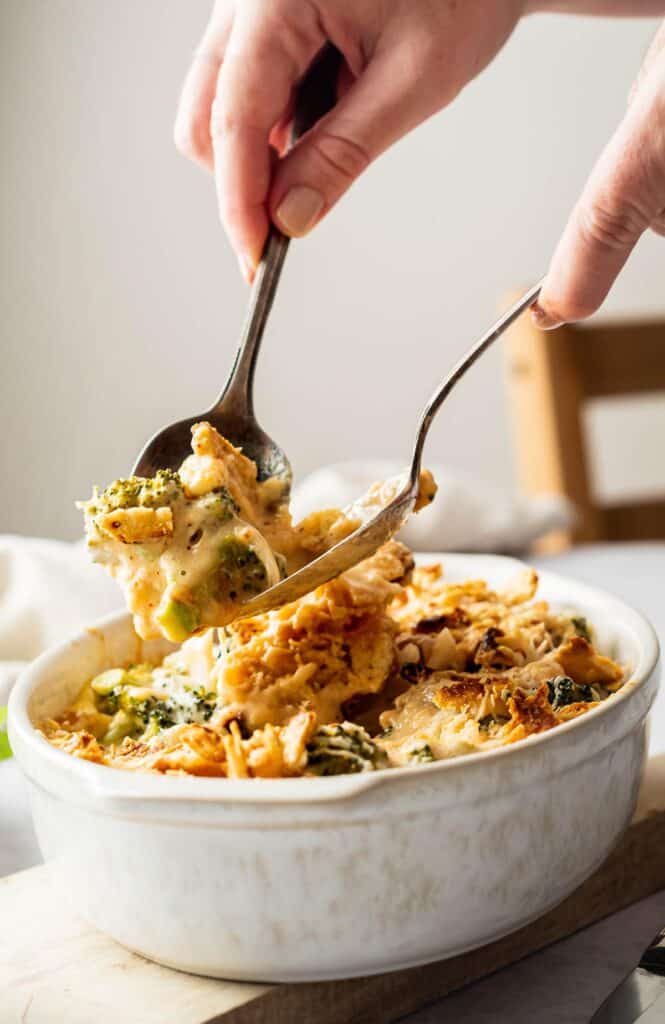 Someone about to serve a helping of broccoli casserole.