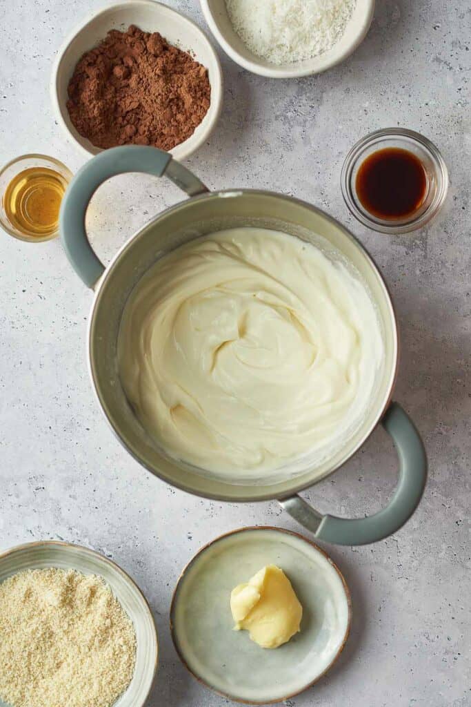 Melted cream in a pan with the other ingredients around it in bowls.
