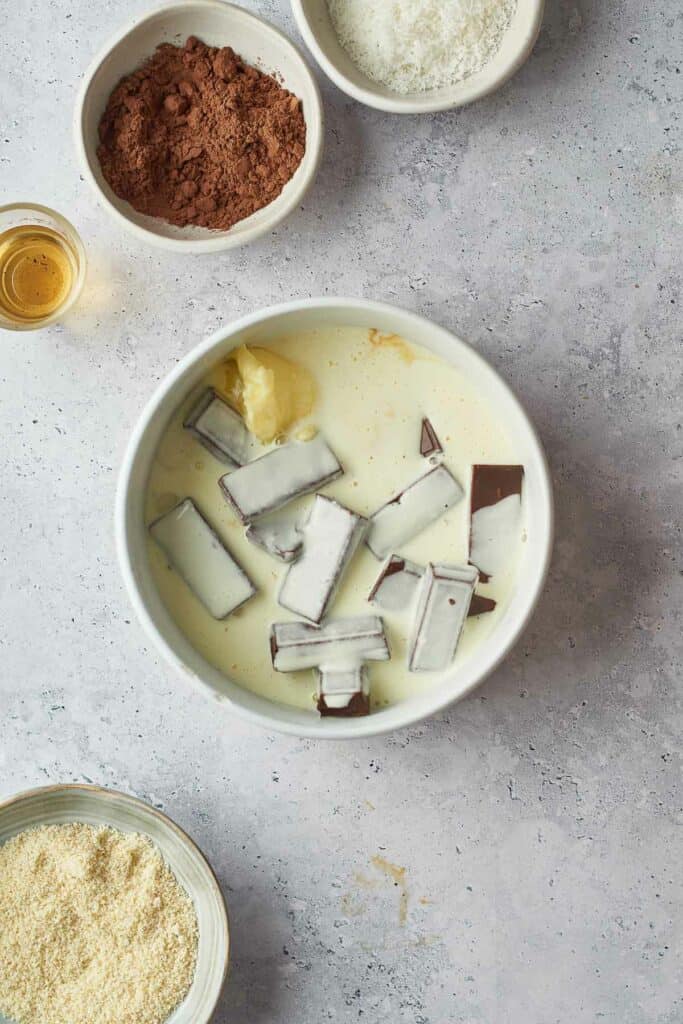 Warm cream poured on top pf broken chocolate and butter.