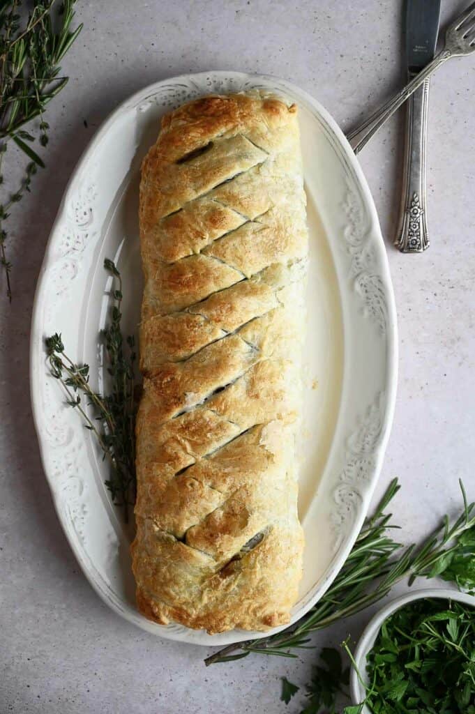 A cooked mushroom wellington on a serving dish.