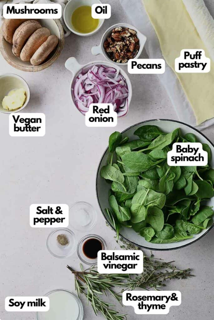 Ingredients needed, mushrooms, oil, pecans, puff pastry, red onion, baby spinach, balsamic vinegar, rosemary, thyme, soy milk, salt, pepper, and vegan butter.