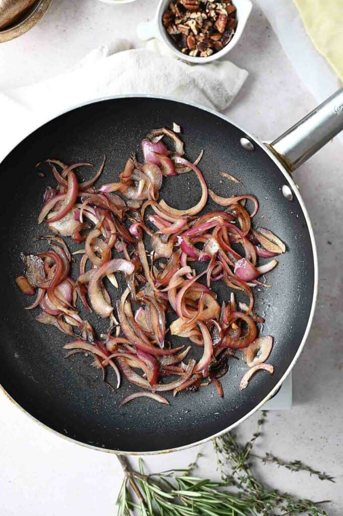 A skillet with onions in.