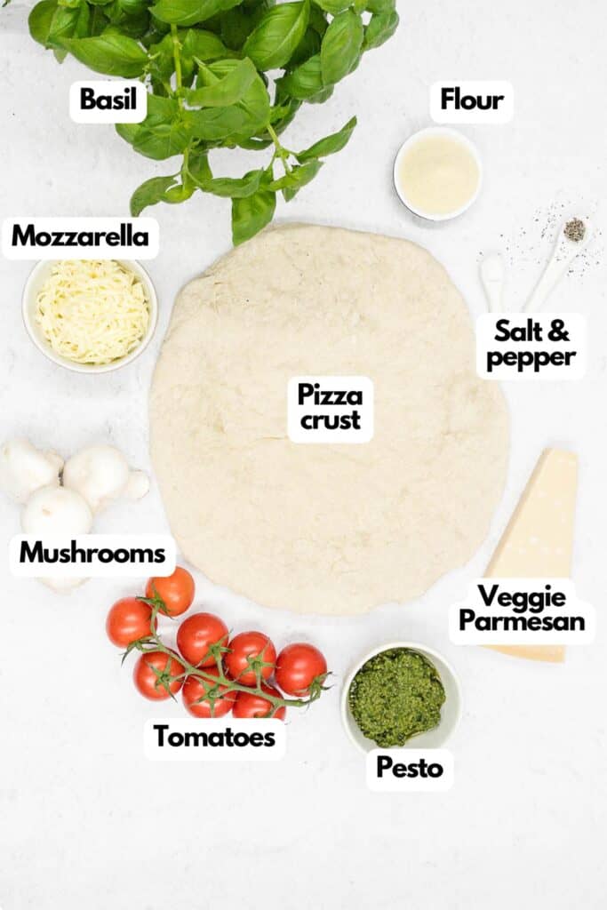 Ingredients needed, basil, flour, salt and pepper, pizza crust, vegetarian Parmesan cheese, basil pesto sauce, tomatoes, mushrooms, and mozzarella cheese.