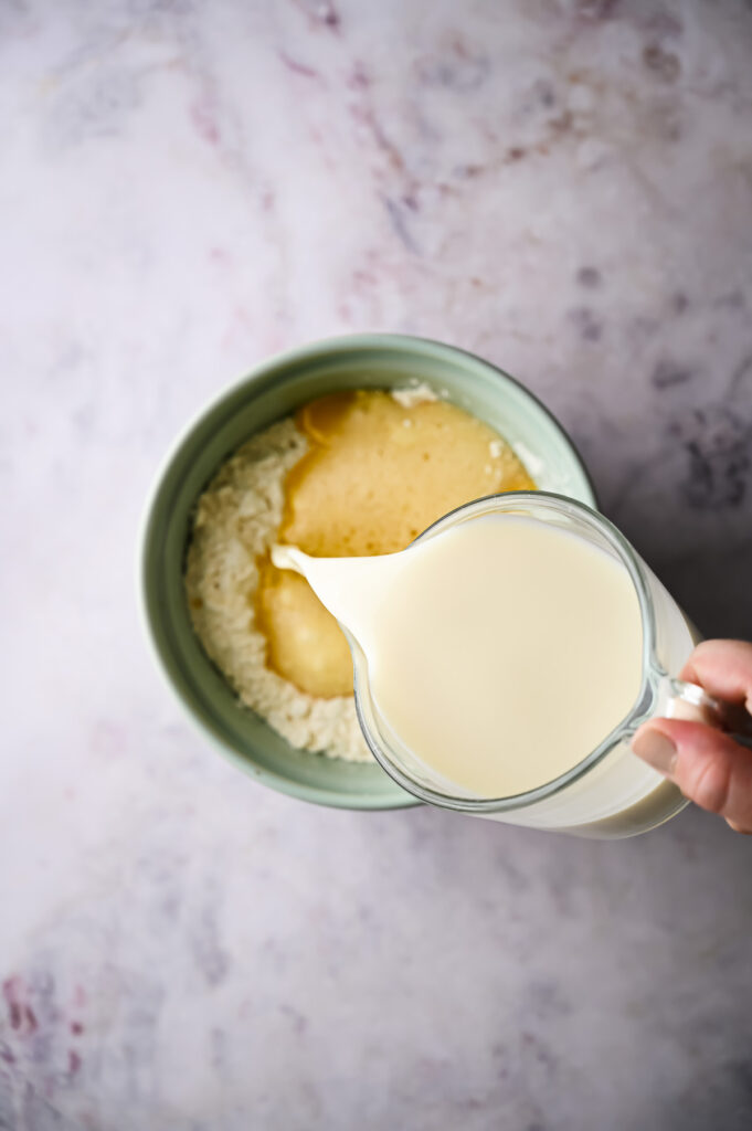 Adding milk to the mixture.