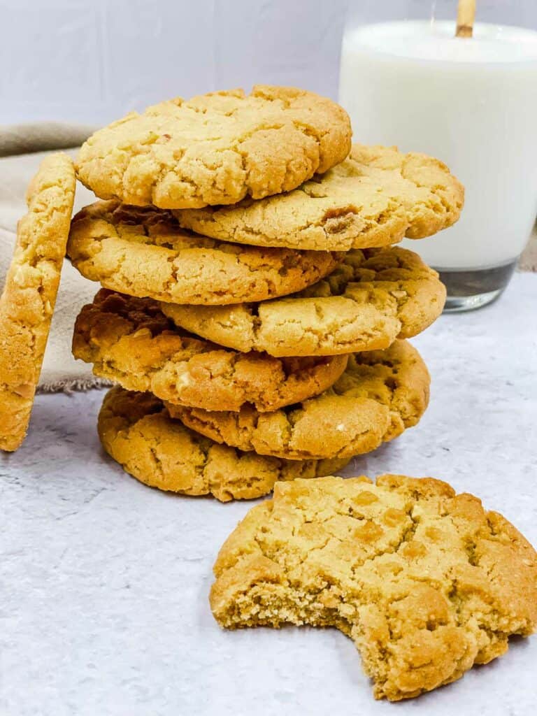 Air fryer peanut butter cookies in a stack with one with a bite out of it.