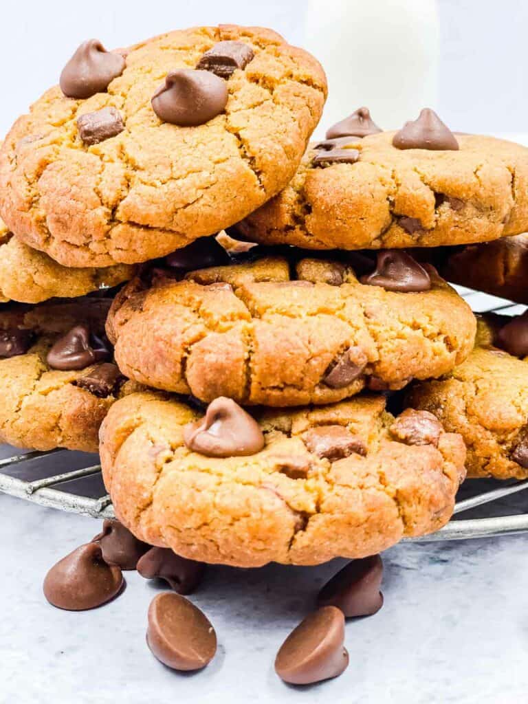 An overflowing stack of air fryer peanut butter chocolate chip cookies on a cooling rack.