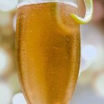 A refreshing champagne cocktail with a lemon twist garnish.