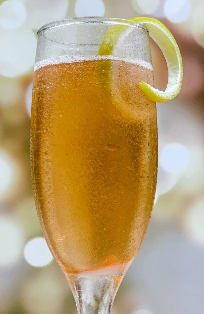 A refreshing champagne cocktail with a lemon twist garnish.