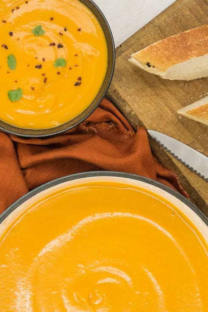 A bowl of sweet potato soup and a pot of it too.