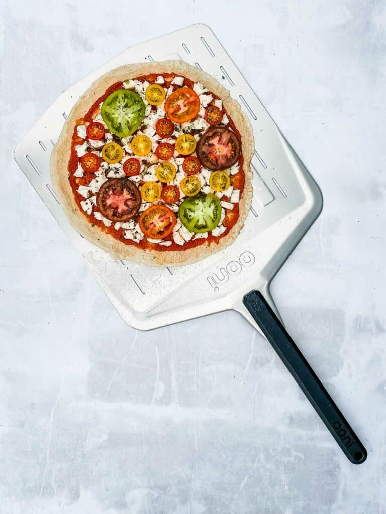 Uncooked pizza on a pizza peel.