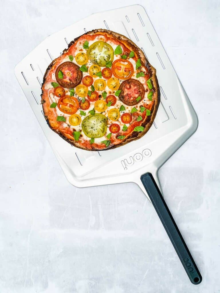 Cooked tomato pizza on a pizza peel.