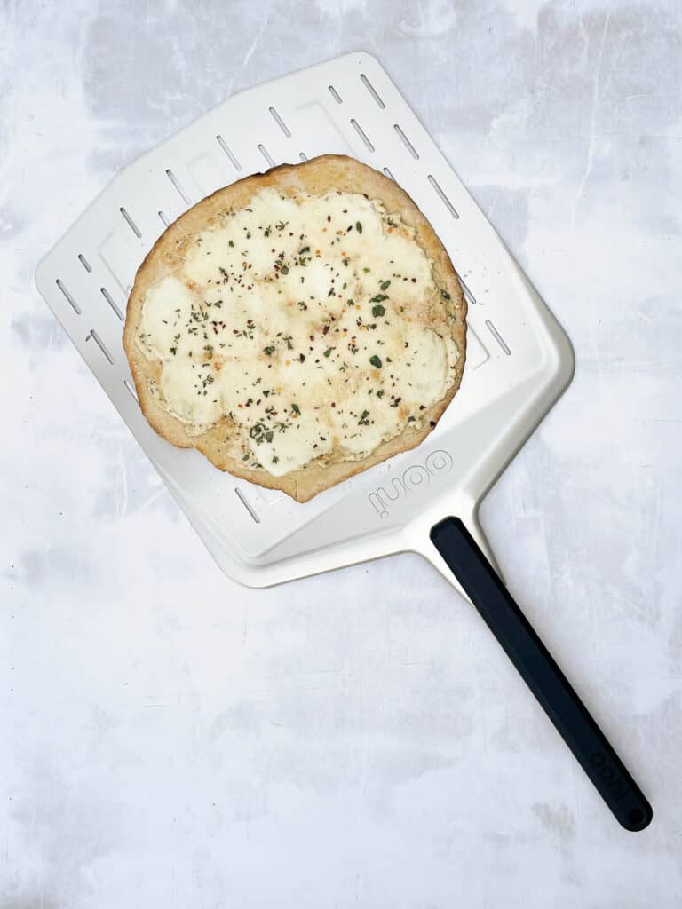 Cooked white pizza on pizza peel.
