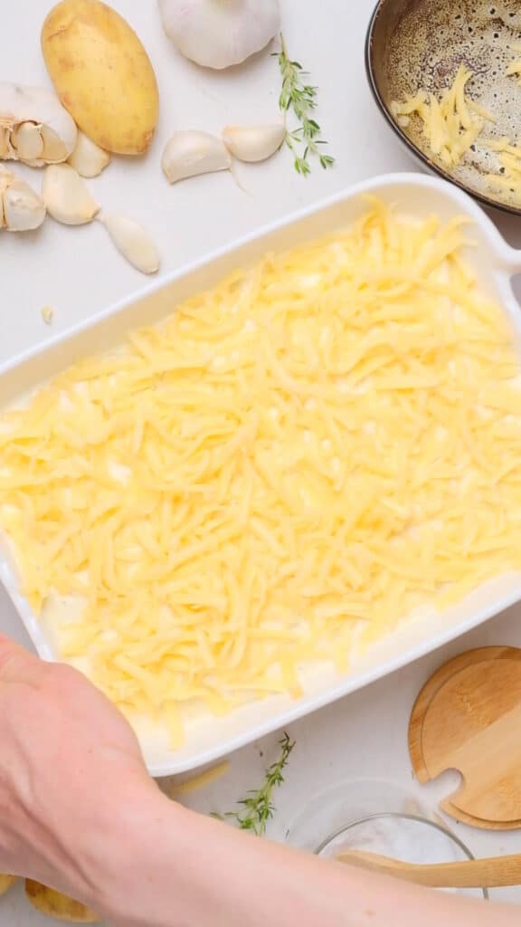 Cheese covering uncooked dauphinoise potatoes.