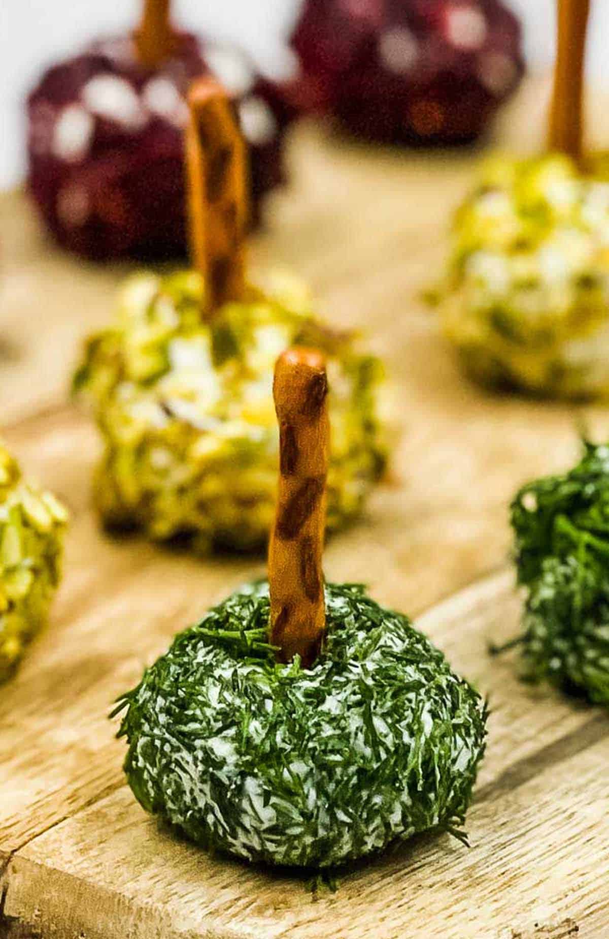Mini goat cheese balls on a board ready to eat.