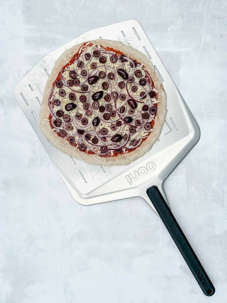 Uncooked pizza on pizza peel.