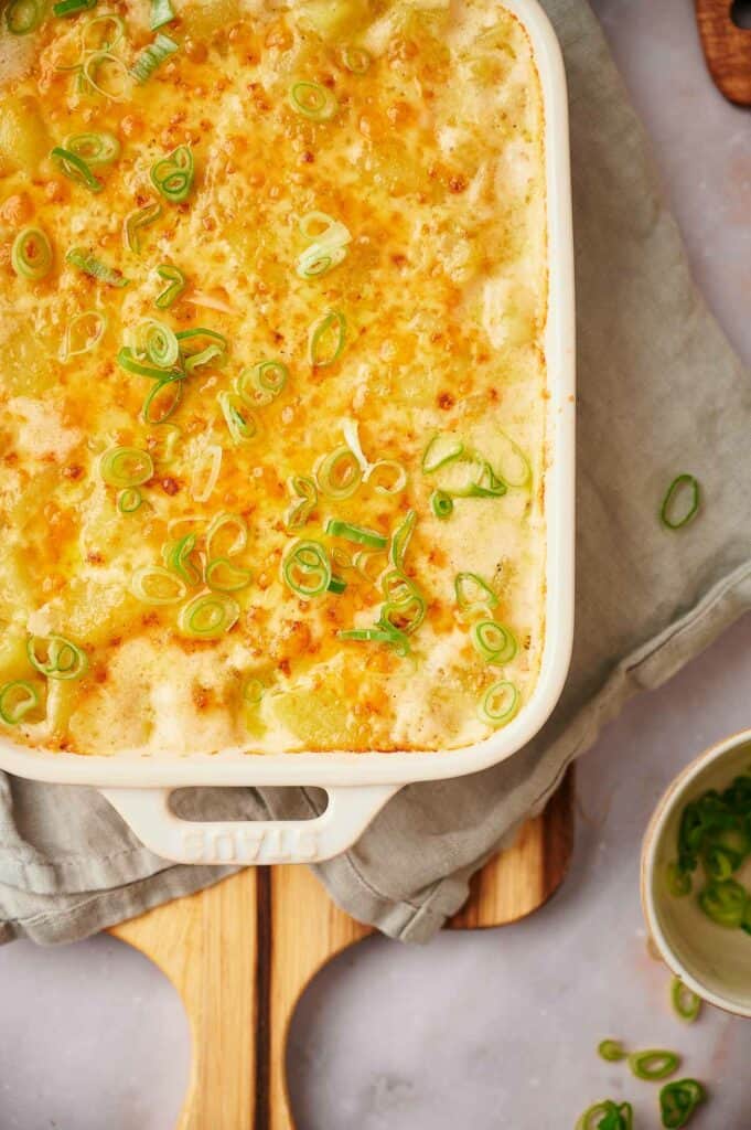 Potato casserole cooked with green onions on top.