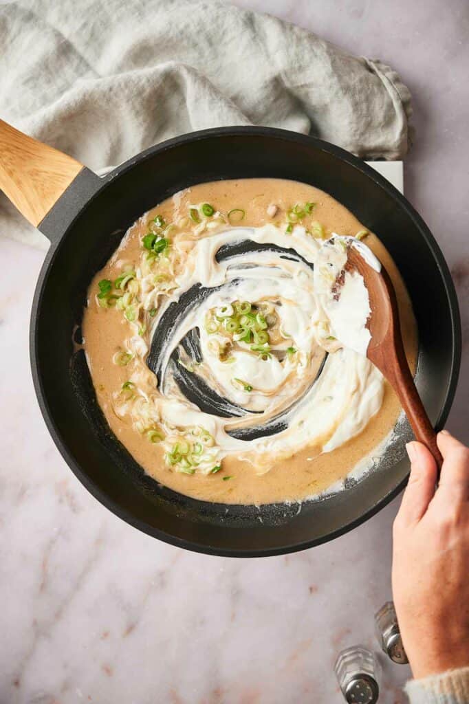 Stirring in the sour cream to the soup mixture.